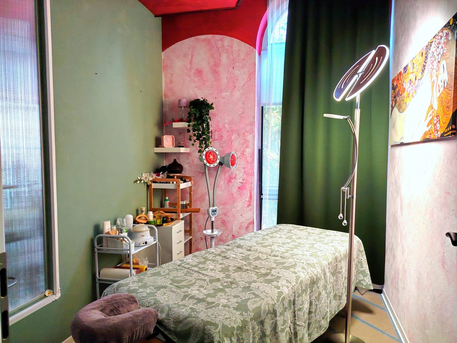 Behandlungsraum mit Liege, Stehlampe und rosa marmorierter Wand