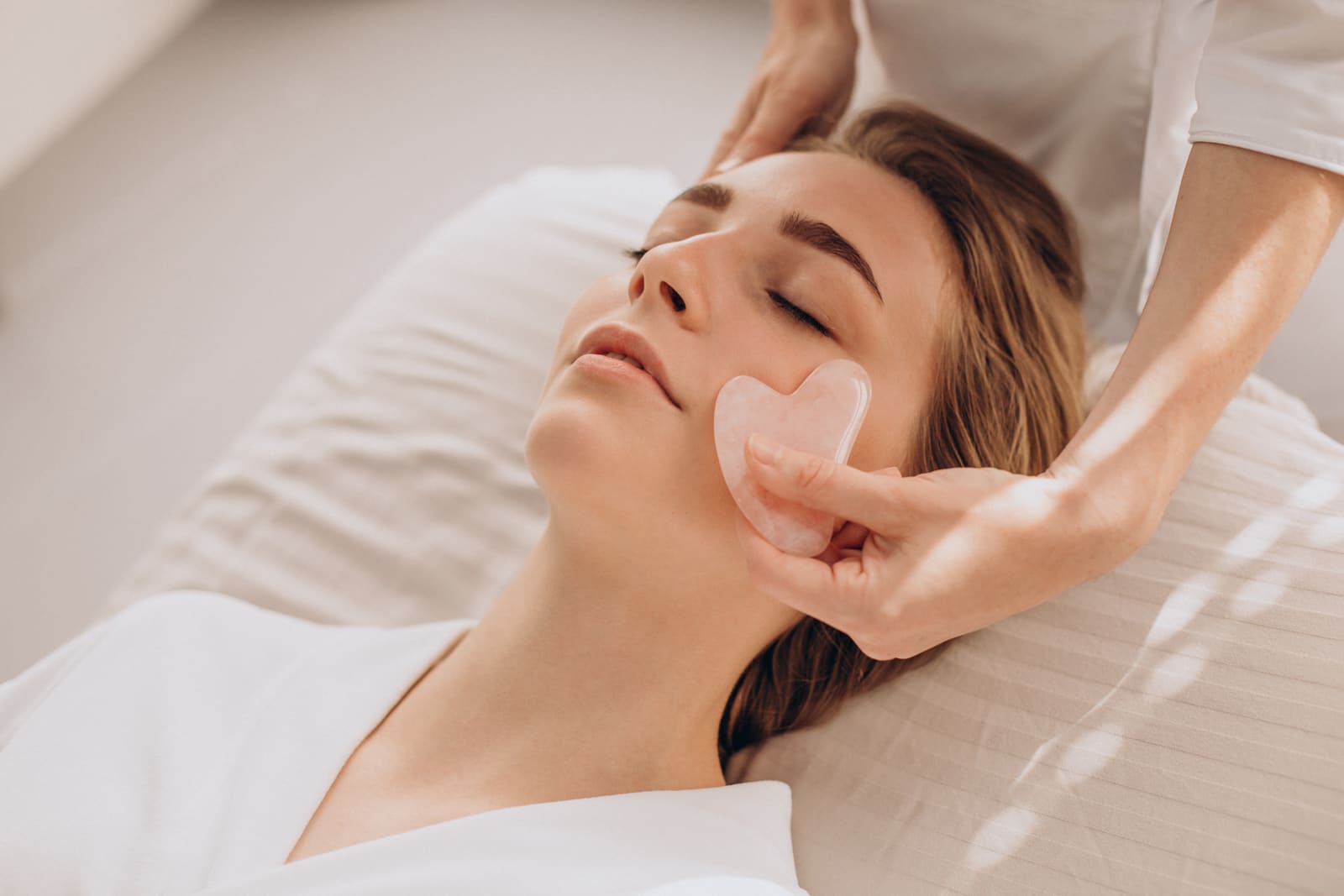 Gesichtsbehandlung mit einem Gua-Sha-Stein aus Rosenquarz